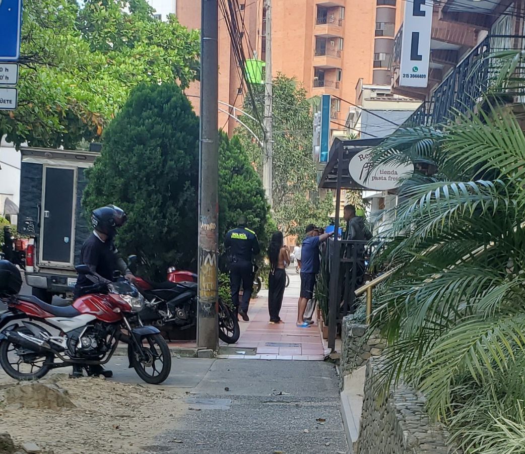 Police questioning at the scene of the crime just outside the Primer Parque de Laureles, Medellin, Colombia.